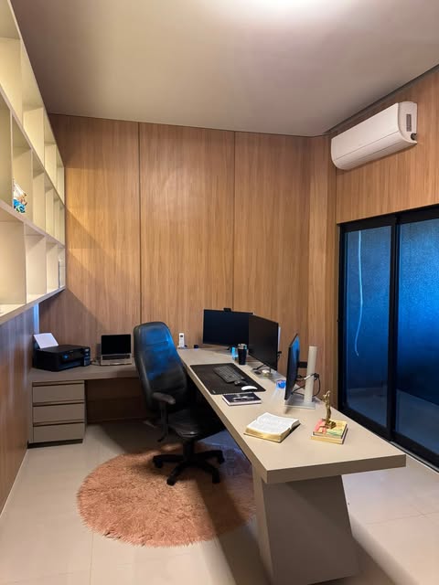 Home office planejado com painel amadeirado e bancada de trabalho