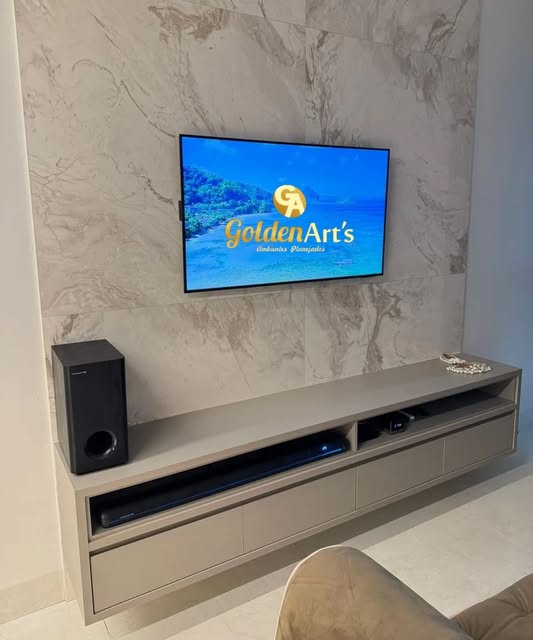 Home theater com painel amadeirado, parede em mármore e rack planejado